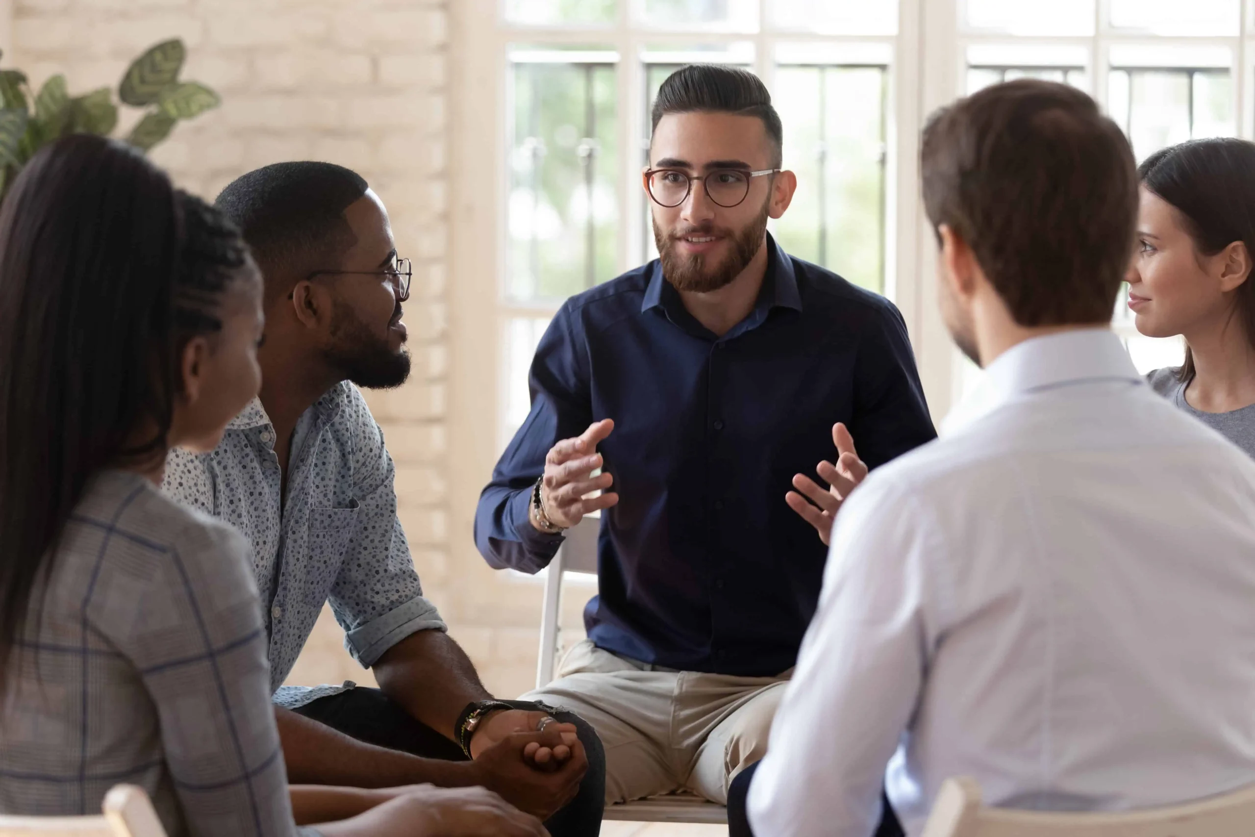 People participate in group therapy at a drug rehab center.